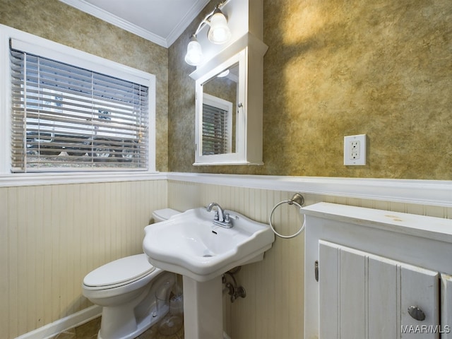 bathroom with toilet, ornamental molding, and wood walls