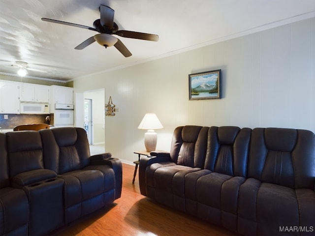 living room featuring light wood-type flooring, ceiling fan, and ornamental molding