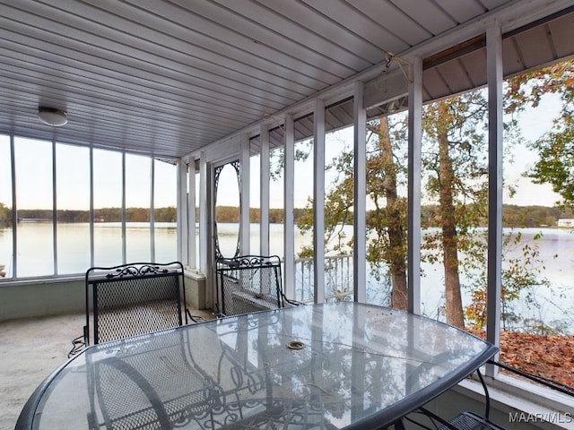 unfurnished sunroom featuring a water view