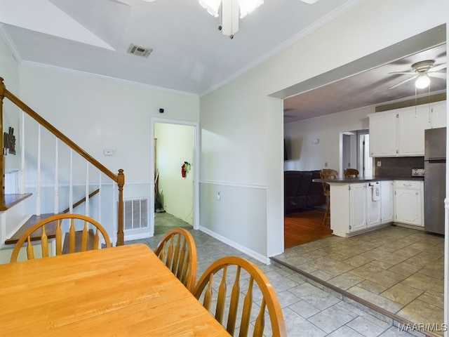 dining space with ceiling fan and ornamental molding