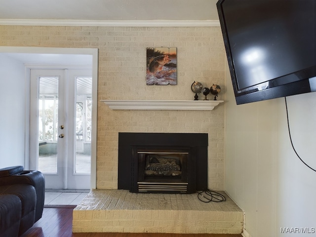 room details featuring a fireplace, crown molding, hardwood / wood-style floors, and french doors