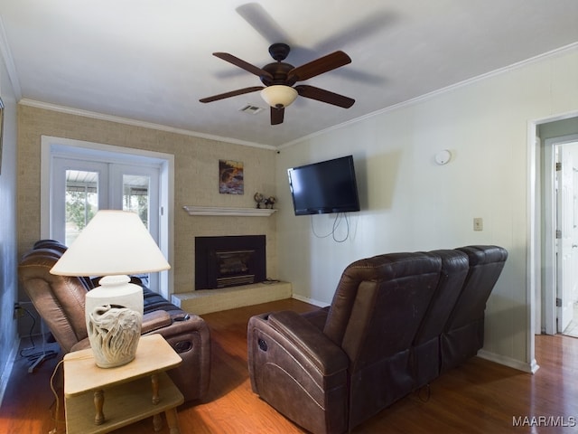 living room featuring a fireplace, crown molding, ceiling fan, and dark wood-type flooring