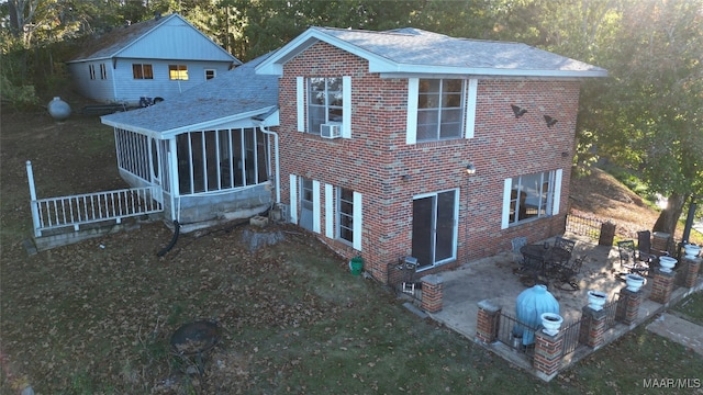 rear view of house with cooling unit, a patio area, and a sunroom