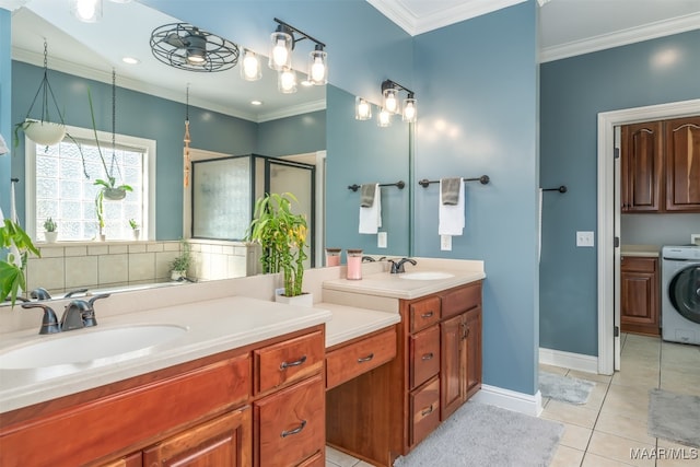 bathroom with tile patterned floors, crown molding, washer / dryer, vanity, and a shower with shower door