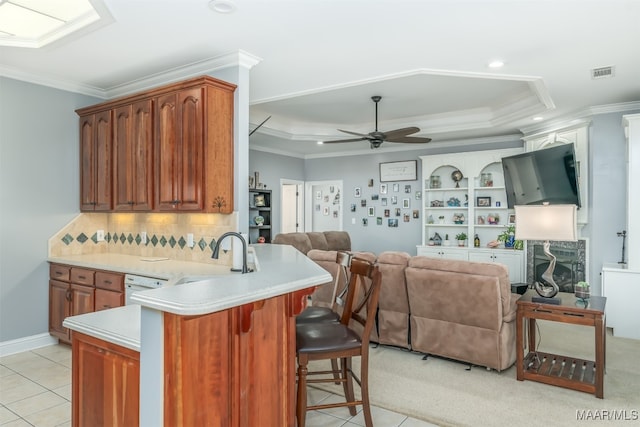 kitchen featuring a kitchen bar, kitchen peninsula, sink, and light tile patterned floors