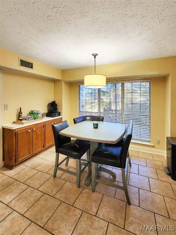 dining space with a textured ceiling and a wealth of natural light