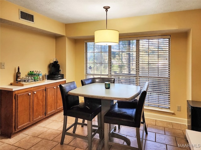 dining area featuring a healthy amount of sunlight and a textured ceiling