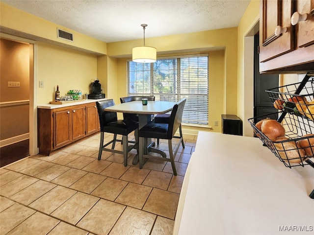 tiled dining area featuring a textured ceiling