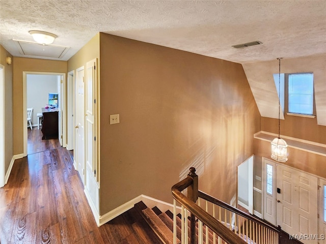 hall featuring wood-type flooring and a textured ceiling