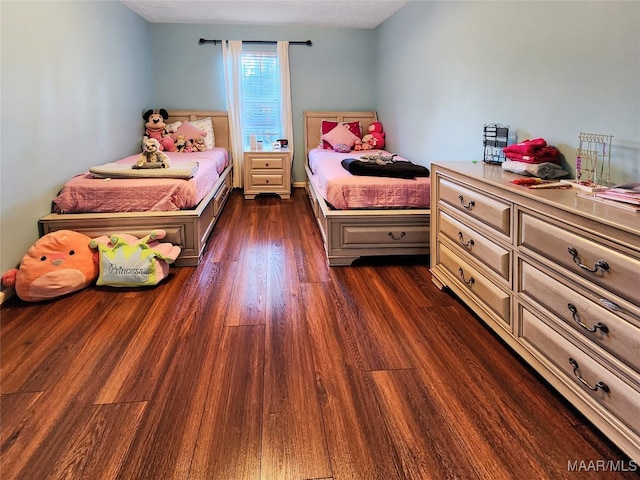 bedroom with dark wood-type flooring and a textured ceiling