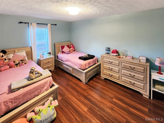 bedroom with dark hardwood / wood-style floors and a textured ceiling