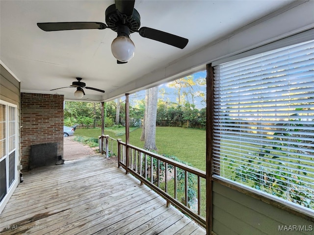 wooden deck featuring a porch, a yard, and ceiling fan