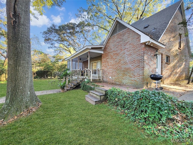 rear view of house featuring covered porch, a yard, and ceiling fan