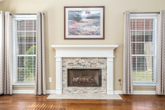 room details featuring hardwood / wood-style floors and a stone fireplace