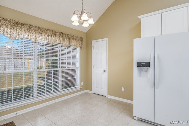 unfurnished dining area featuring an inviting chandelier, light tile patterned flooring, and vaulted ceiling