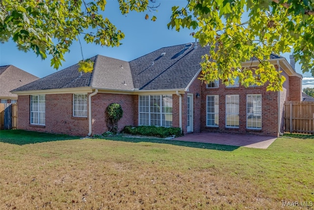 rear view of property with a lawn and a patio area