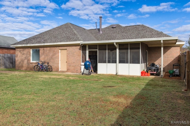 rear view of house with a yard and a sunroom