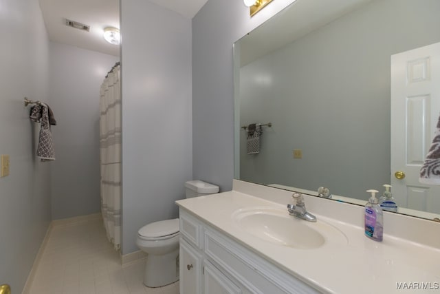 bathroom with tile patterned flooring, vanity, and toilet