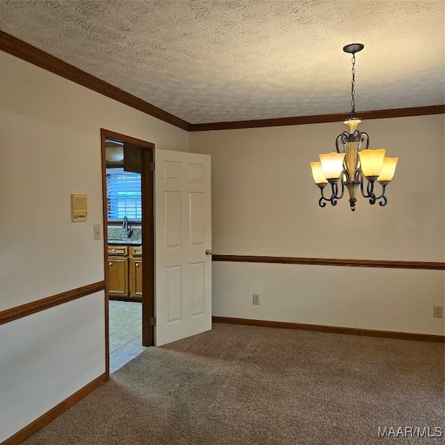 carpeted empty room with a textured ceiling, an inviting chandelier, ornamental molding, and sink