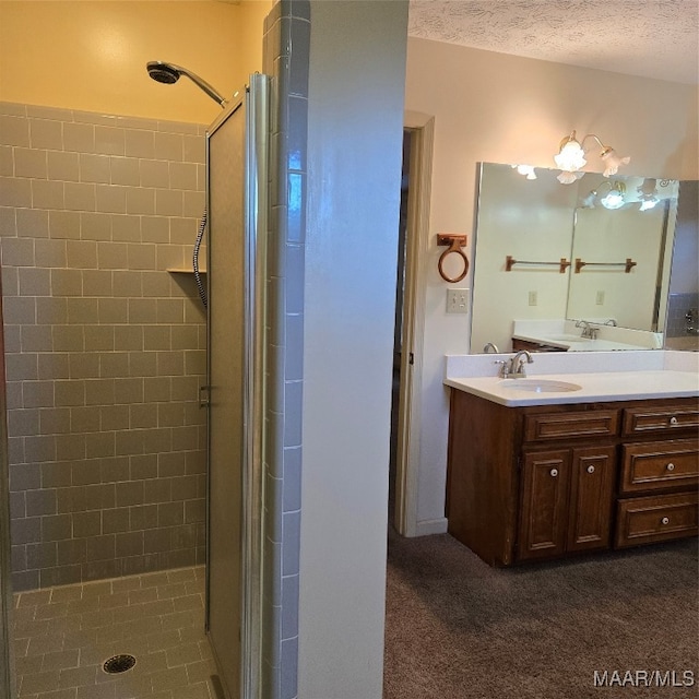 bathroom with vanity, a textured ceiling, and walk in shower