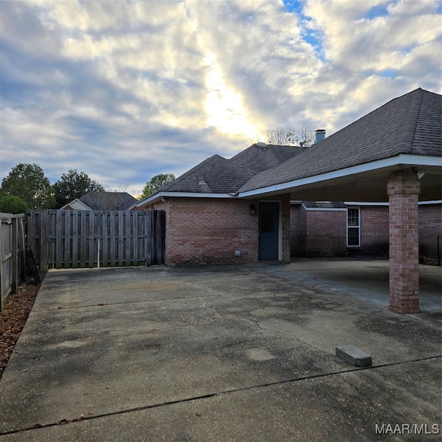 property exterior at dusk with a patio area