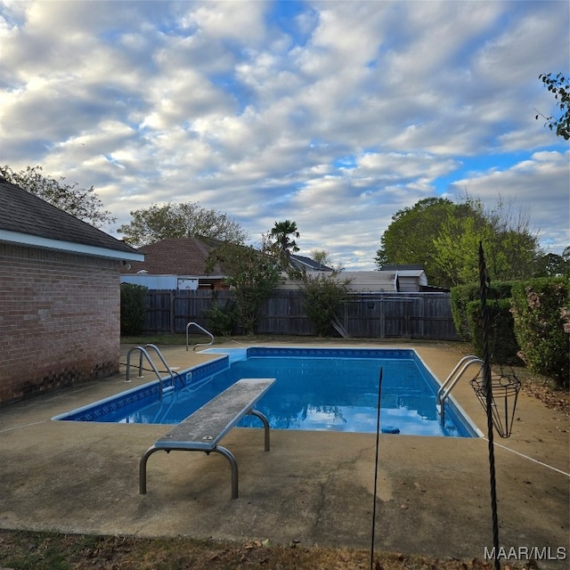 view of pool with a diving board