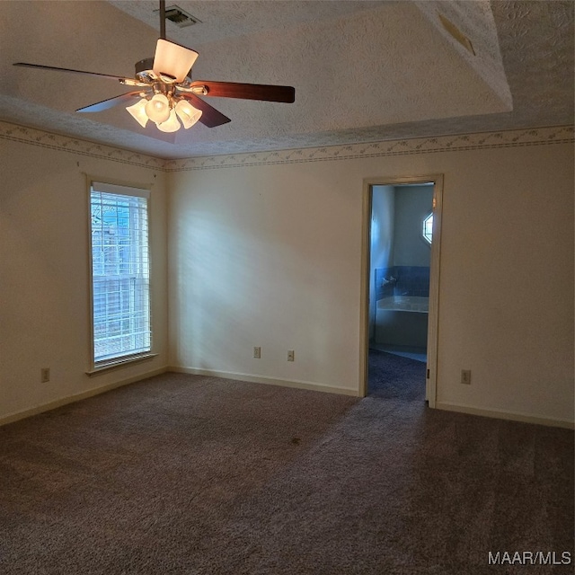 carpeted empty room with ceiling fan and a textured ceiling