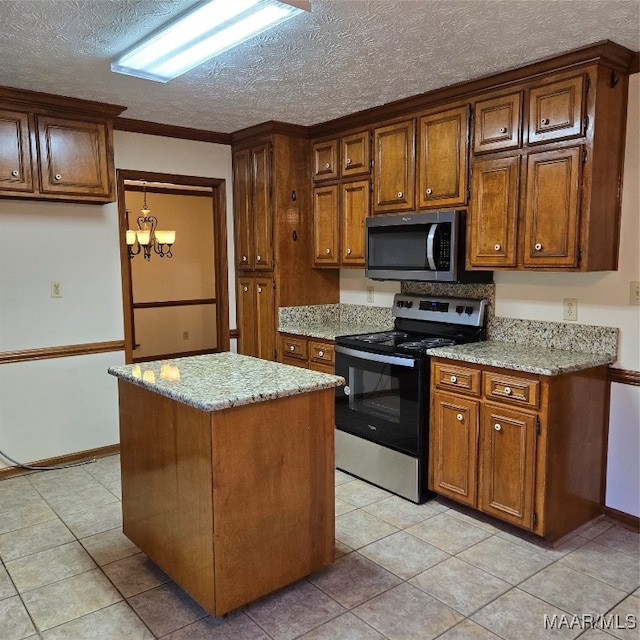 kitchen with light stone countertops, light tile patterned floors, a textured ceiling, a kitchen island, and appliances with stainless steel finishes