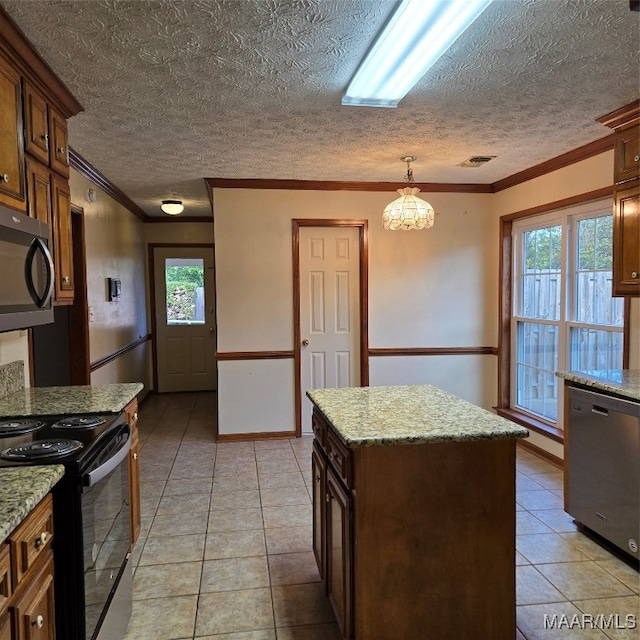 kitchen with hanging light fixtures, a center island, stainless steel appliances, and a wealth of natural light