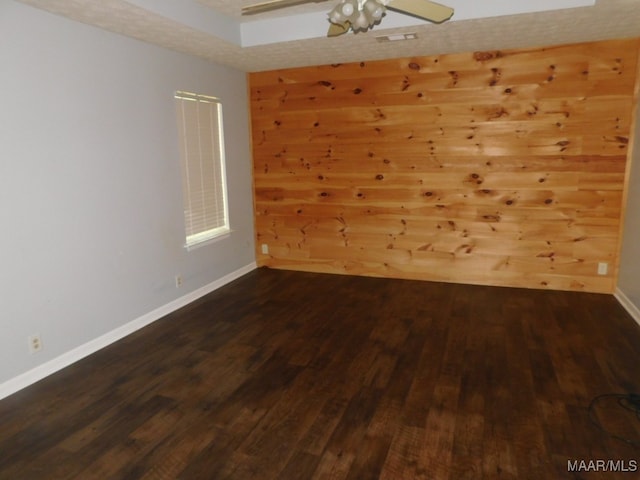 unfurnished room with ceiling fan and dark wood-type flooring