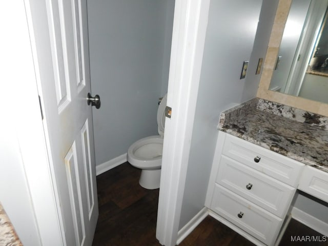 bathroom with hardwood / wood-style floors, vanity, and toilet