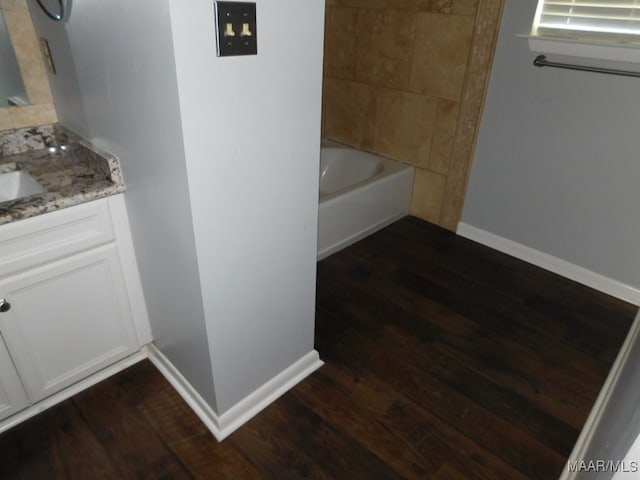 bathroom featuring wood-type flooring, vanity, and shower / bath combination