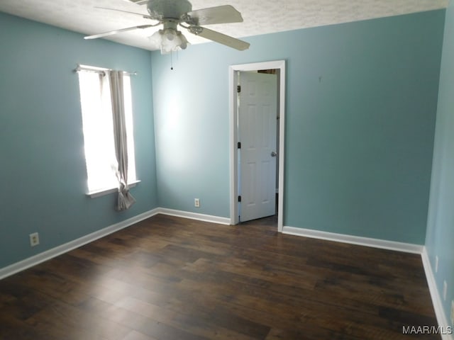 unfurnished room with a textured ceiling, ceiling fan, and dark wood-type flooring