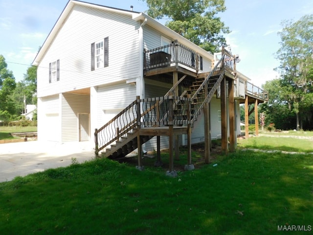 back of house featuring a lawn, a garage, and a deck