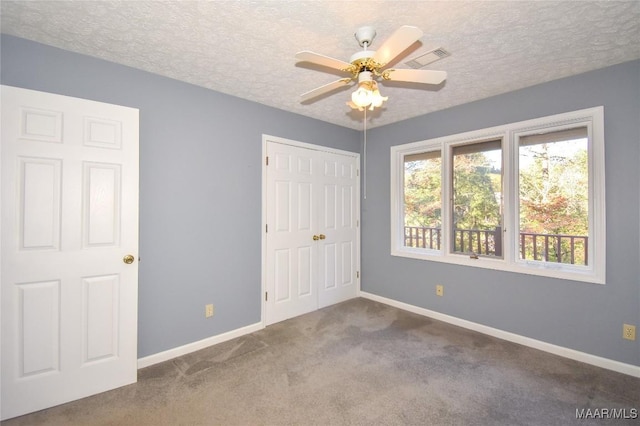 171 Griffith Ln, Tallassee, AL 36078 - unfurnished bedroom featuring baseboards, carpet, a closet, a textured ceiling, and a ceiling fan