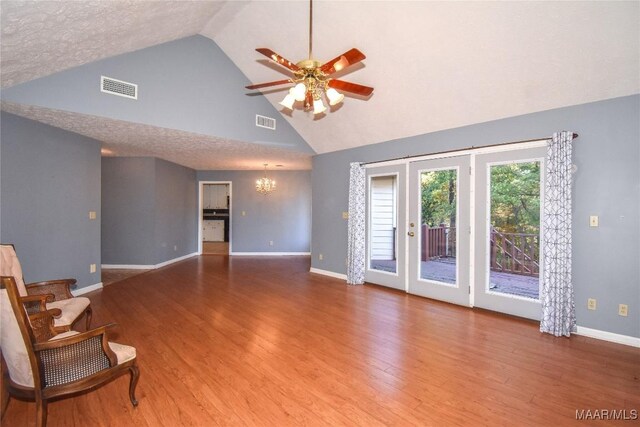171 Griffith Ln, Tallassee, AL 36078 - unfurnished living room featuring high vaulted ceiling, baseboards, a chandelier, ceiling fan, and wood finished floors