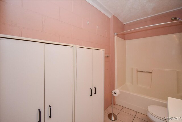 171 Griffith Ln, Tallassee, AL 36078 - bathroom featuring tile patterned floors, a textured ceiling,  shower combination, toilet, and concrete block wall
