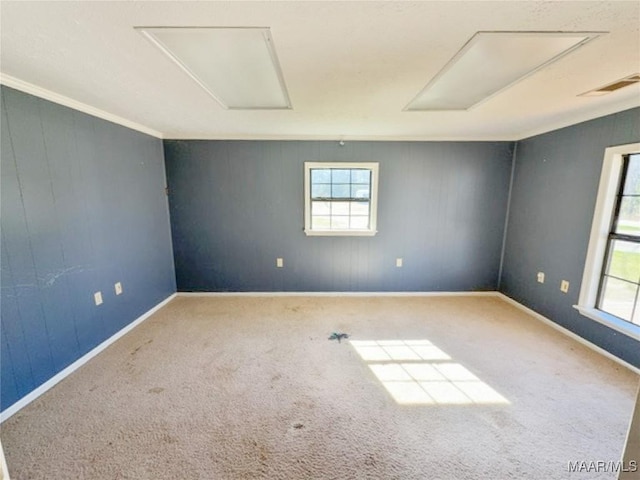 unfurnished room with carpet floors, baseboards, visible vents, and attic access