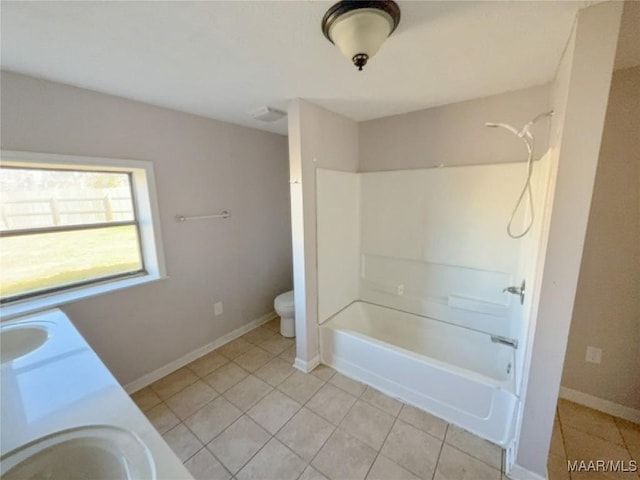 full bath featuring toilet, baseboards, a sink, and shower / bathing tub combination