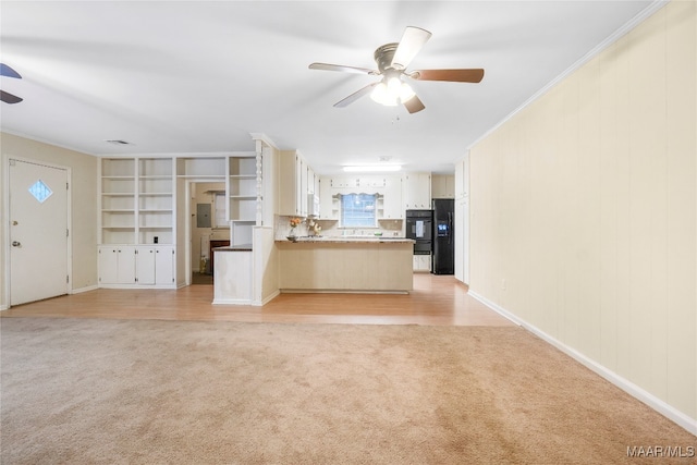 unfurnished living room featuring ceiling fan, light colored carpet, and ornamental molding