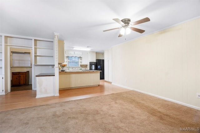 unfurnished living room featuring ceiling fan, ornamental molding, and light wood-type flooring