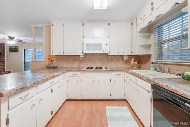 kitchen with sink, light hardwood / wood-style flooring, kitchen peninsula, white appliances, and white cabinets