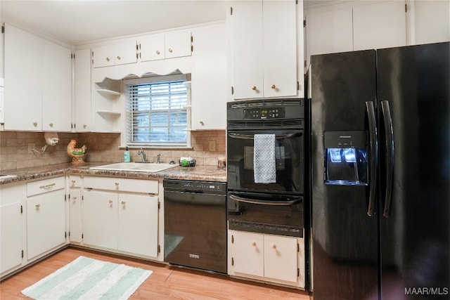 kitchen featuring black appliances, light hardwood / wood-style floors, white cabinets, and sink