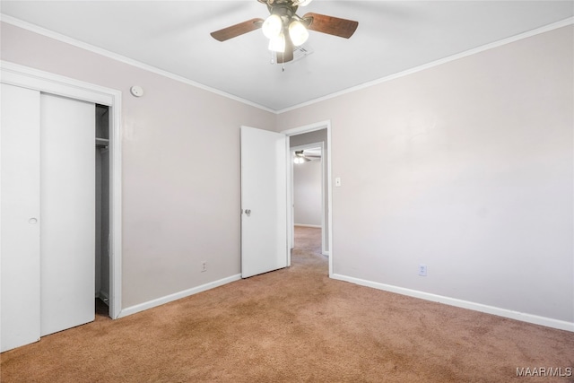 unfurnished bedroom featuring ceiling fan, crown molding, light carpet, and a closet