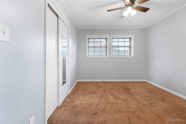 carpeted empty room featuring ceiling fan and ornamental molding