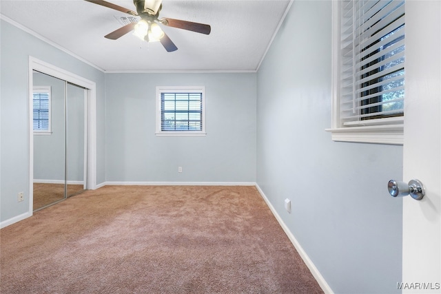 unfurnished bedroom featuring carpet flooring, a closet, ceiling fan, and ornamental molding