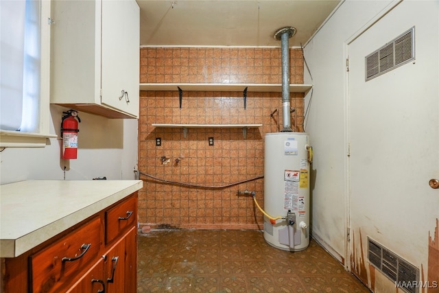 laundry room featuring cabinets and water heater