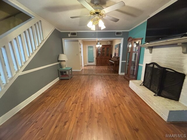 unfurnished living room with crown molding, a fireplace, ceiling fan, and hardwood / wood-style flooring