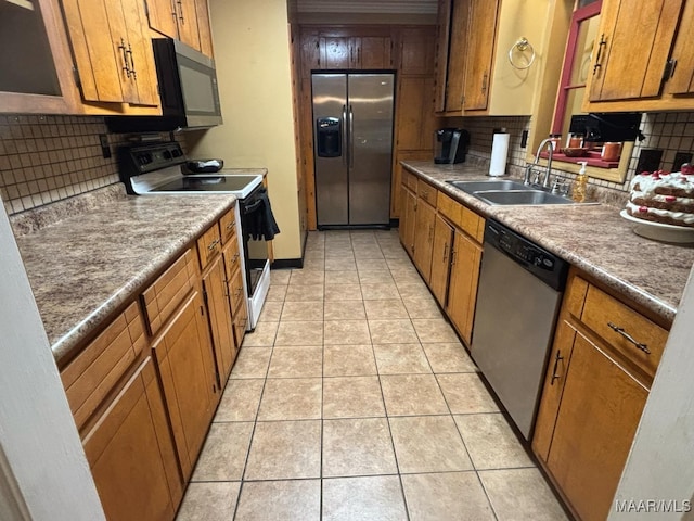 kitchen featuring tasteful backsplash, light tile patterned flooring, appliances with stainless steel finishes, and sink