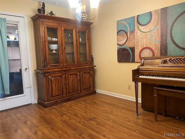 misc room with dark wood-type flooring and a chandelier